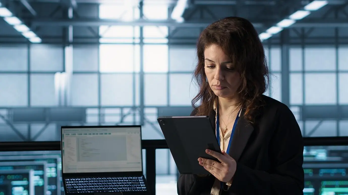 Администратор в дата-центре использует технологии искусственного интеллекта на планшете.