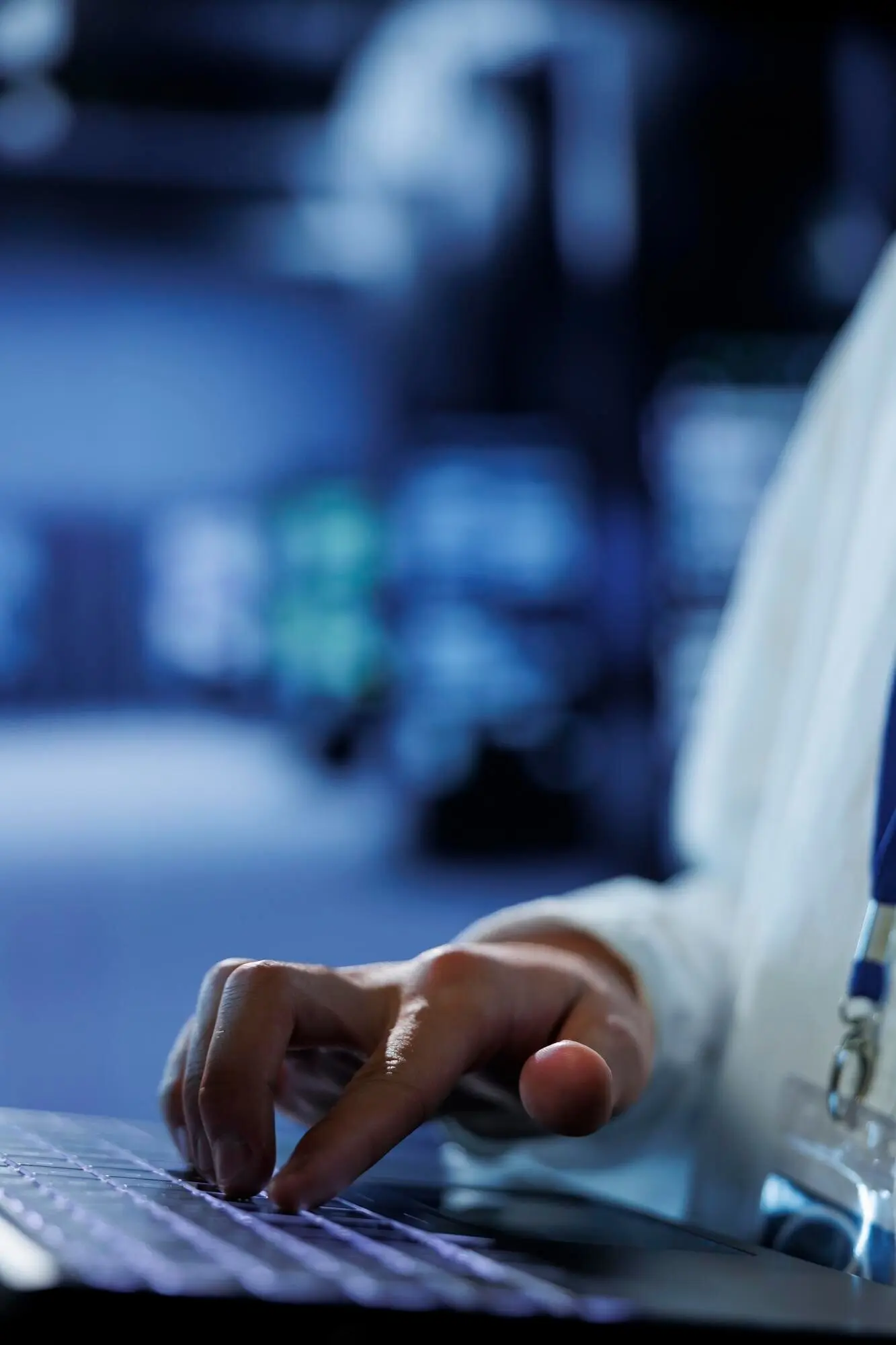 Крупный план: опытный администратор в центре обработки данных использует ноутбук, чтобы предотвратить перегрузку системы в периоды пикового трафика, обеспечивая в серверном узле достаточную пропускную способность сети для бесперебойной работы.